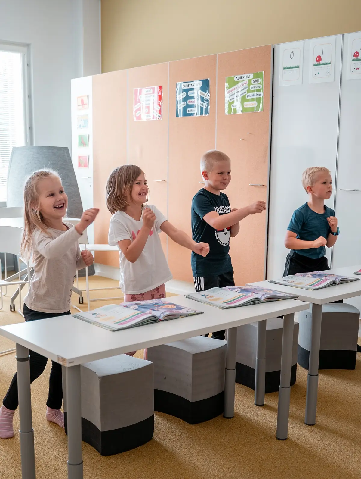 Teacher in a classroom with a laptop and students in the background